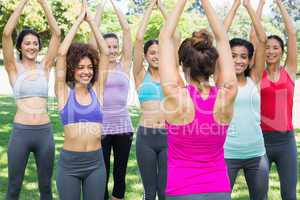 Women exercising with female instructor at park