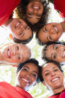 Female soccer team forming huddle