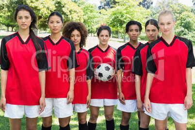 Female soccer team with ball at park