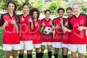 Female soccer team gesturing thumbs up at park