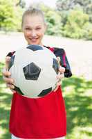 Female soccer player showing ball at park