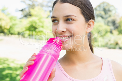 Sporty woman drinking water
