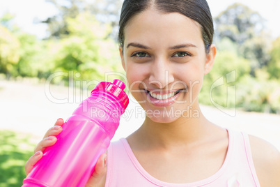 Happy sporty woman holding water bottle