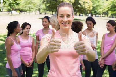 Volunteer gesturing thumbs up at breast cancer campaign