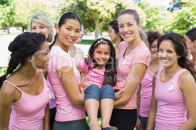 Women carrying girl during breast cancer awareness