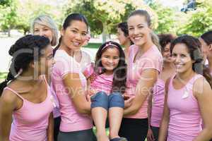 Women carrying girl during breast cancer awareness