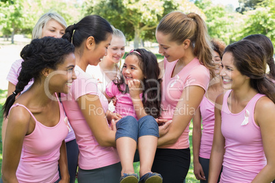 Volunteers carrying girl during breast cancer campaign