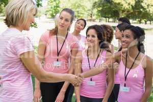 Participants shaking hands during breast cancer awareness