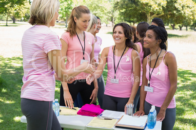 Volunteer greeting participants during breast cancer awareness
