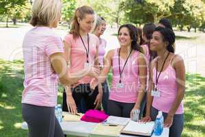 Volunteer greeting participants during breast cancer awareness