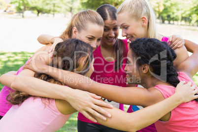 Participants of breast cancer marathon forming huddle
