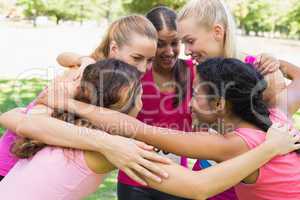 Participants of breast cancer marathon forming huddle