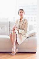 Stylish thoughtful businesswoman sitting on sofa