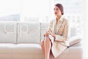 Thoughtful businesswoman sitting on sofa