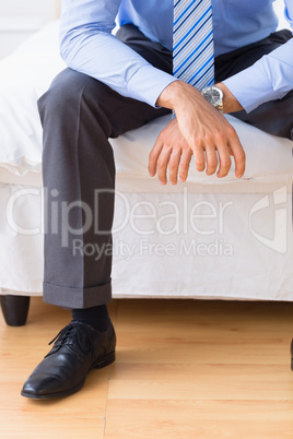 Businessman sitting on his bed