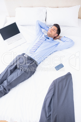Napping businessman lying on his bed