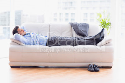 Tired businessman sleeping on a sofa