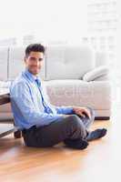 Handsome businessman sitting on the floor