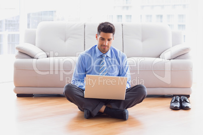 Businessman sitting on floor using laptop