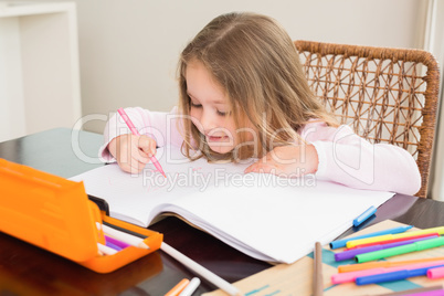 Cute little girl colouring at the table
