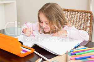 Cute little girl colouring at the table