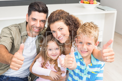 Happy parents giving thumbs up with their young children