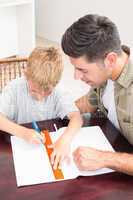 Father helping son with homework at table