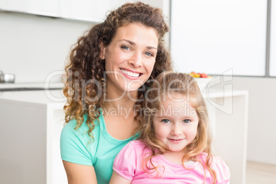 Happy mother and daughter looking at camera