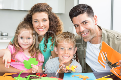 Happy young family doing arts and crafts at the table