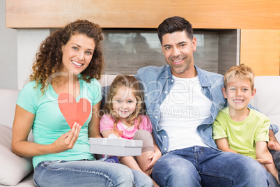 Smiling family sitting on sofa celebrating a birthday