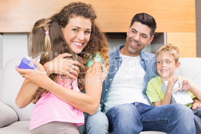 Little girl giving present to her happy mother