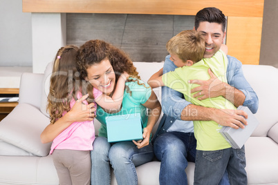 Young siblings giving presents to their parents