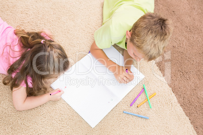 Siblings colouring on the rug