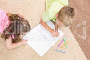 Siblings colouring on the rug