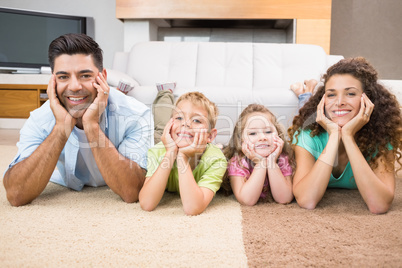 Happy siblings lying on the rug posing with their parents