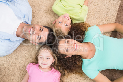 Happy family lying on the rug in a circle