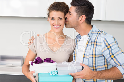 Smiling woman holding many gifts from her partner