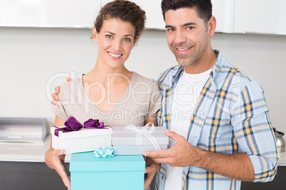 Cheerful woman holding many gifts from her partner