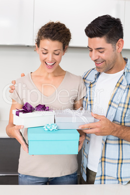 Surprised woman holding many gifts from her partner