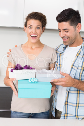 Shocked woman holding many gifts from her partner