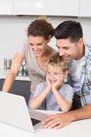 Parents using laptop with their son