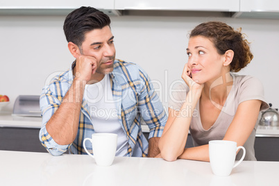 Fed up couple having coffee looking at each other