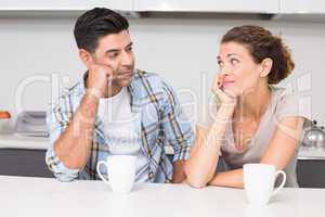 Fed up couple having coffee looking at each other