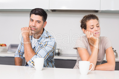 Troubled couple having coffee not talking to each other