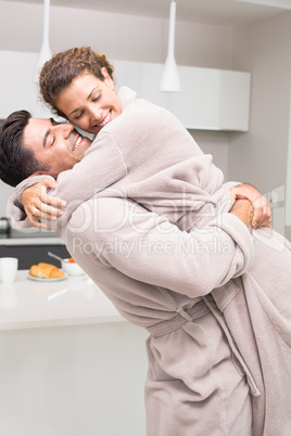 Man lifting and hugging his partner in the morning