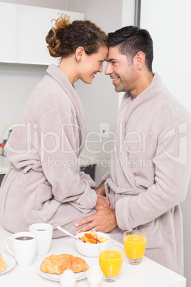 Romantic couple in bathrobes having breakfast together