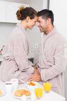 Romantic couple in bathrobes having breakfast together