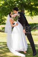 Romantic newlywed couple kissing in park