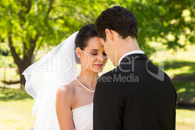 Romantic newlywed couple standing in park