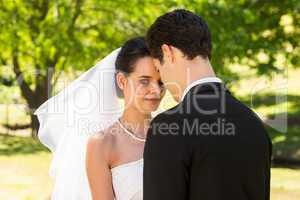 Romantic newlywed couple standing in park